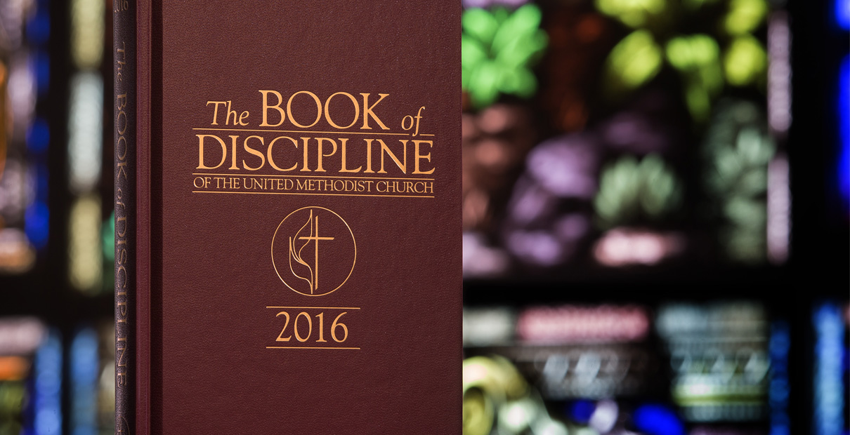 The Book of Discipline 2016 in front of colorful stained glass