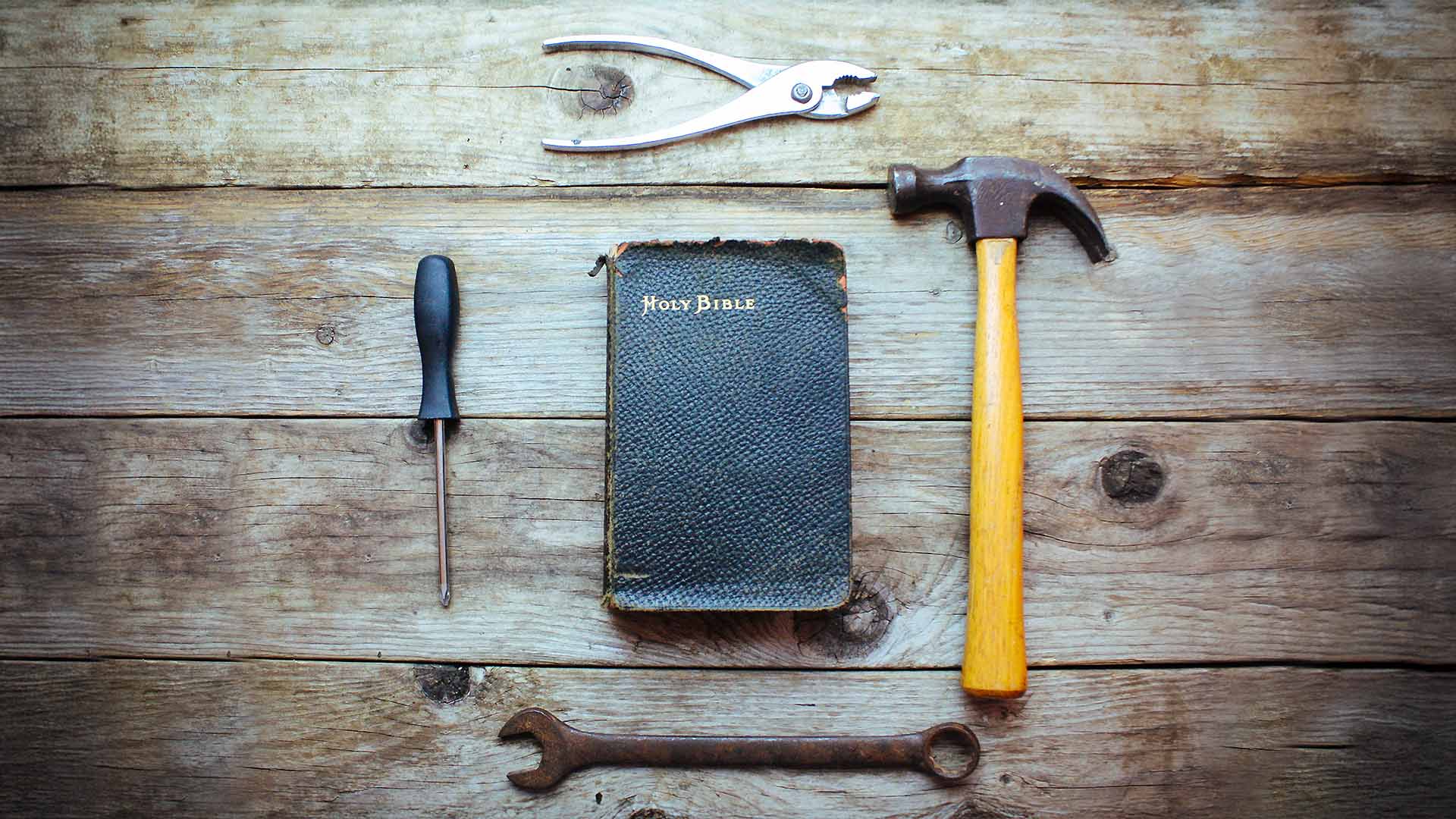 Four tools in a circle around a Bible