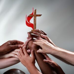 diverse hands on cross and flame