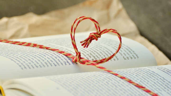 Braided string in the shape of a heart over a book