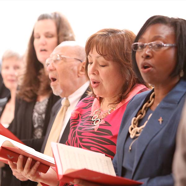 Methodists holding hymnals and signing