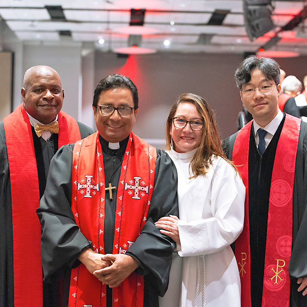 Four people pose for a group photo after ordination