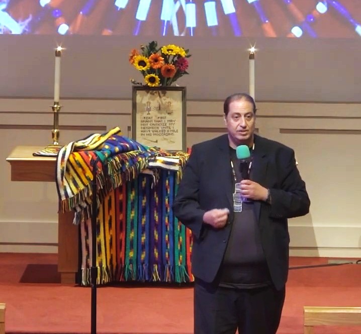 Mark Deese speaks in front of the altar with Native American decor.
